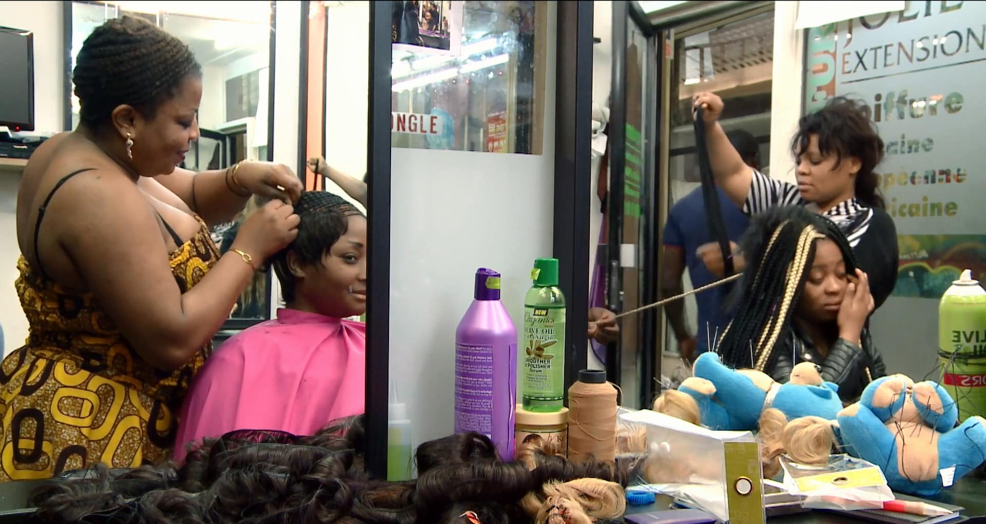 Image de clientes afro-descendantes dans un salon de coiffure. 